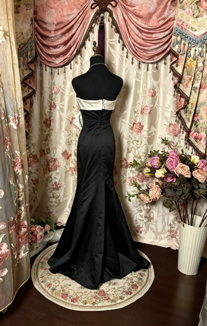 Back view of black satin mermaid prom dress showing zipper closure.