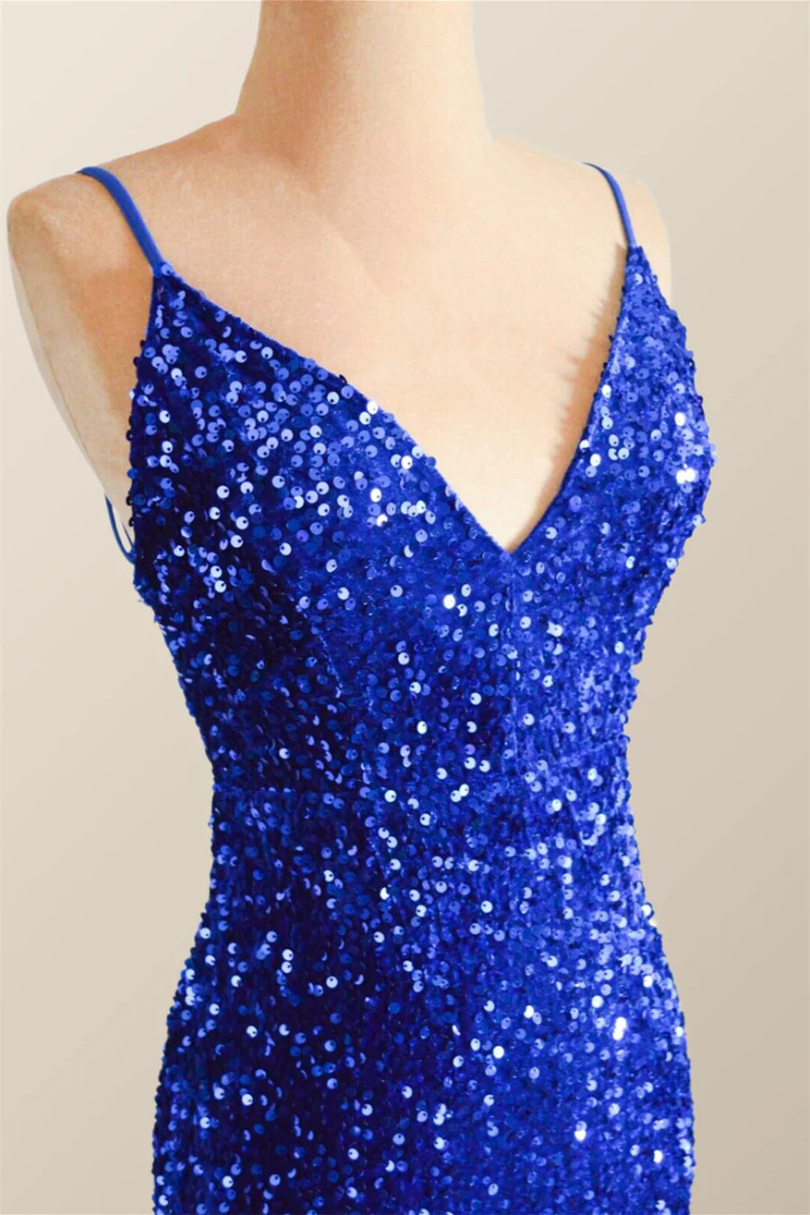 Side view of a model wearing a shimmering dark sequin mermaid gown, highlighting the floor-length hem and subtle train.