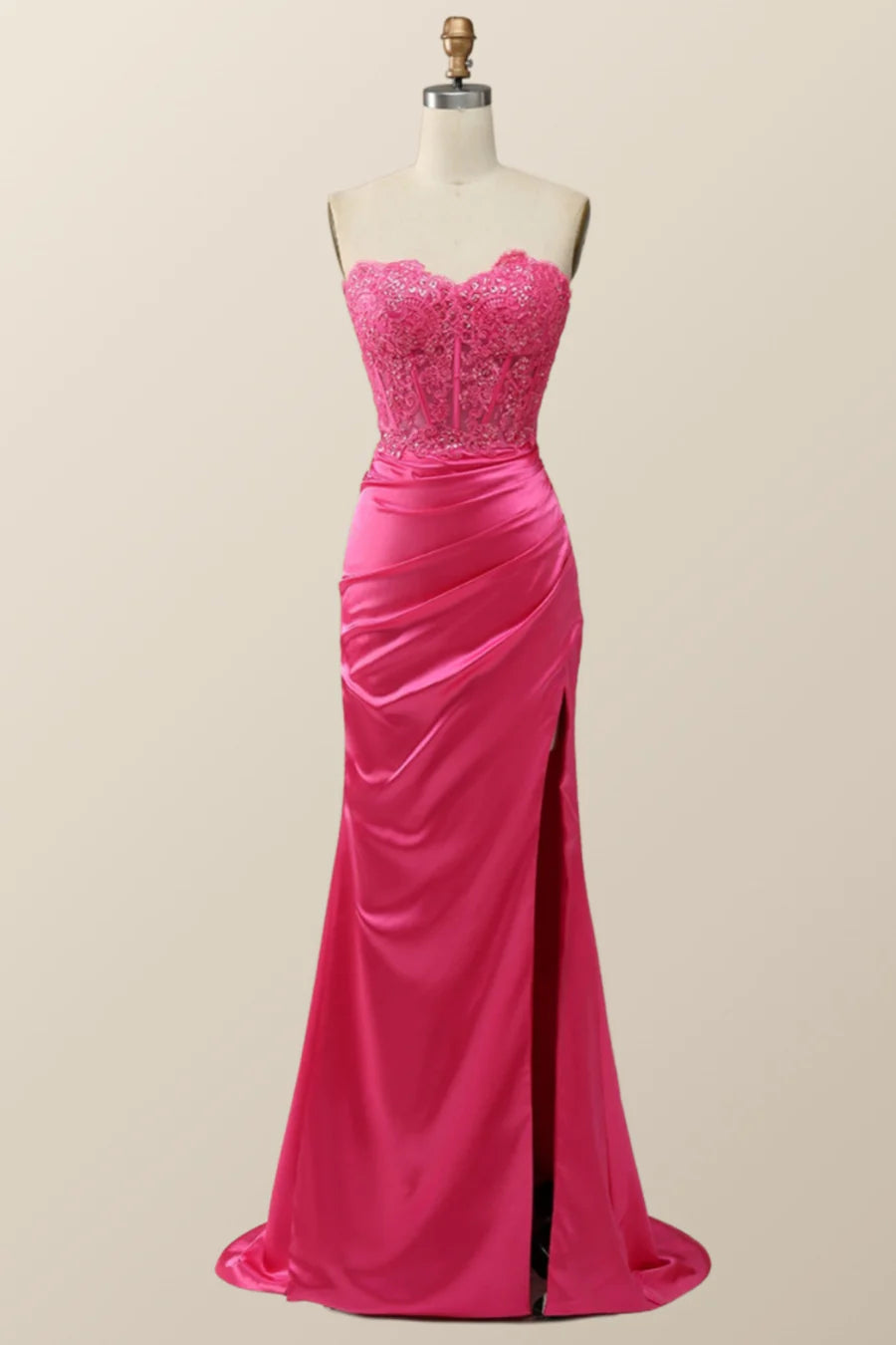 Model wearing a strapless beaded lace mermaid evening dress with a high slit.