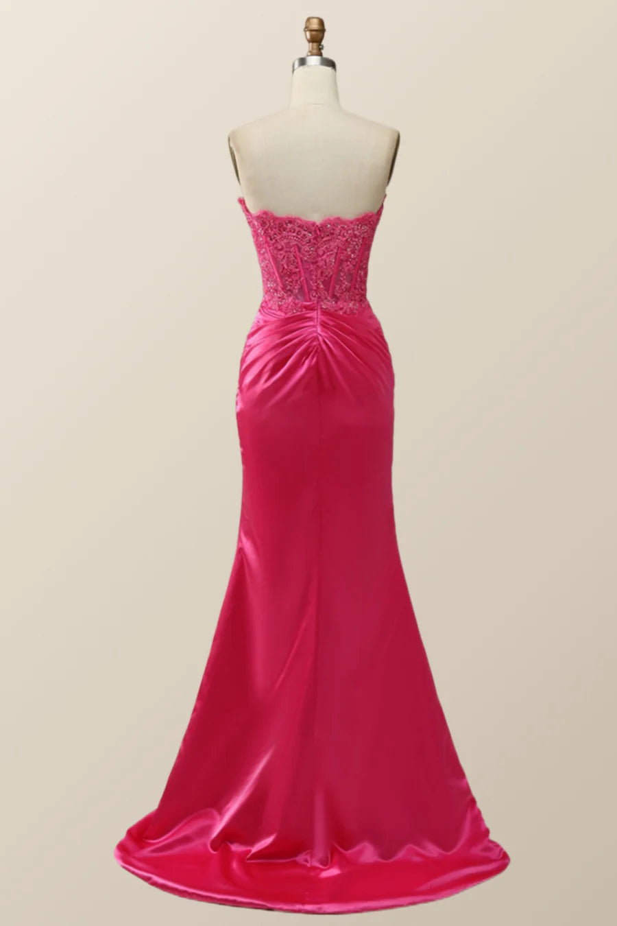 Back view of a model in a lace-up corset mermaid evening dress.