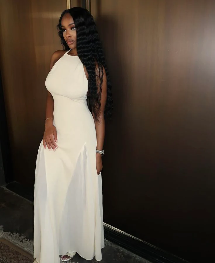 Woman in elegant A-line chiffon prom dress with open back.