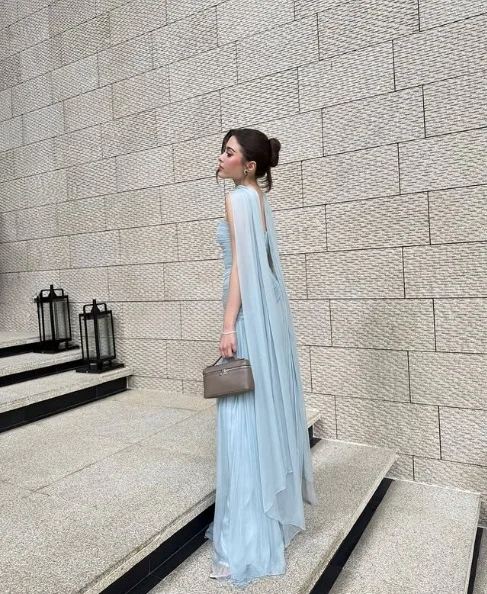 Close-up of strapless ruched bodice and draped shawl on chiffon prom dress.