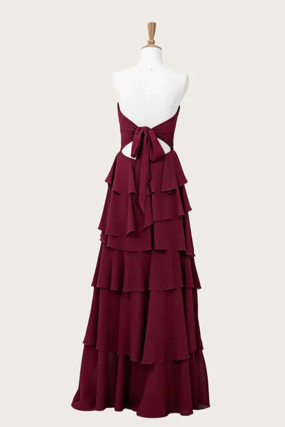 Elegant flowy chiffon A-line strapless high-low burgundy evening dress with tie-back, back view.