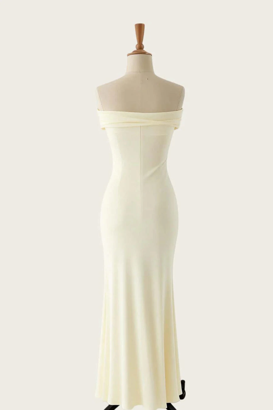 Model wearing an elegant form-fitting mermaid off-shoulder evening gown, back view.
