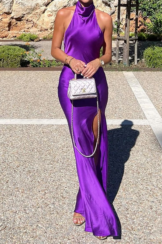 Model in elegant satin mermaid prom gown, showing open back and high slit.