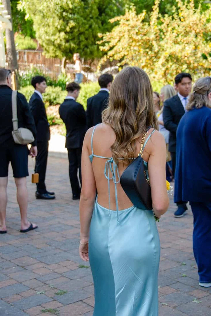 Back view of elegant satin prom dress showing tie-back straps.
