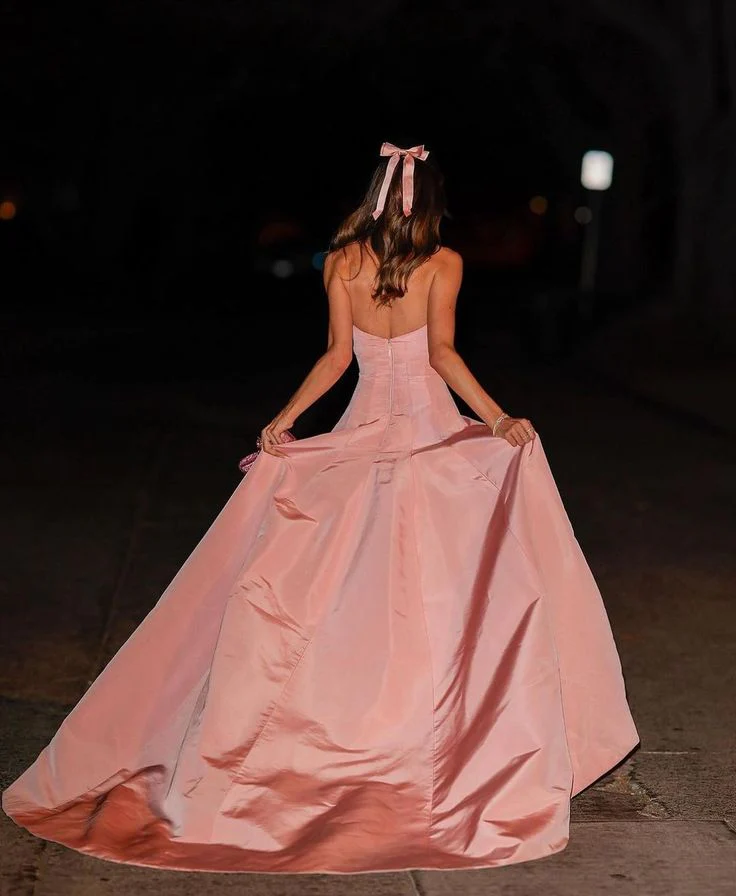 Full view of a pink satin ball gown prom dress with a voluminous skirt.
