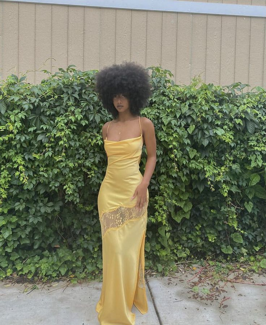 Model wearing a glamorous satin mermaid prom dress with cowl neck and spaghetti straps.
