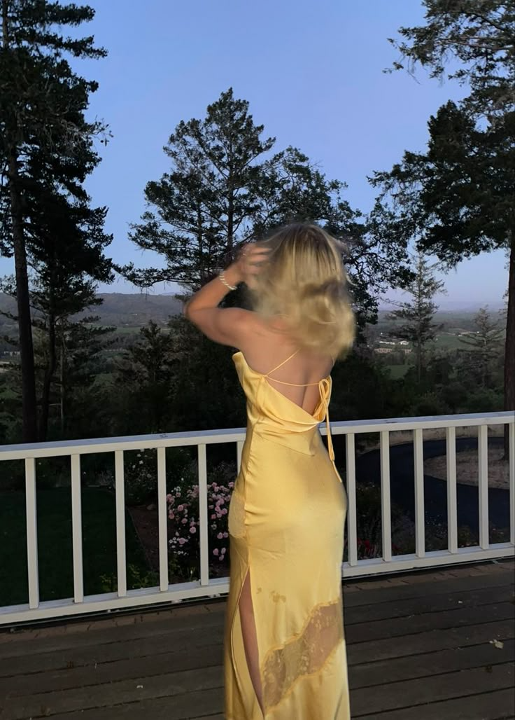 Full view of a model posing in a floor-length satin mermaid prom dress.