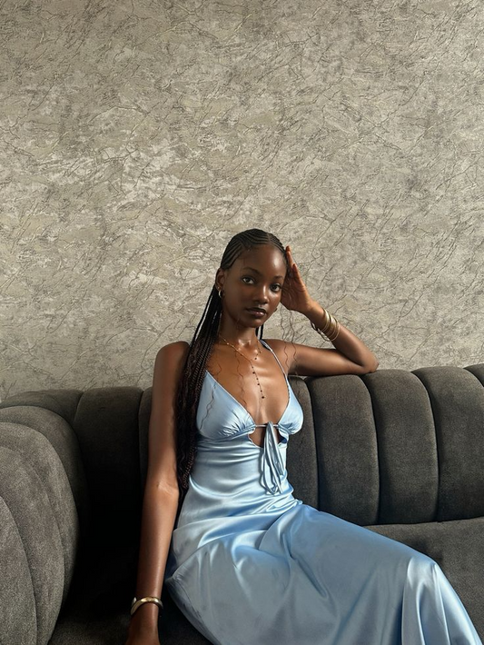 Model wearing a lustrous satin sheath V-neck spaghetti strap tie-back floor-length prom dress.