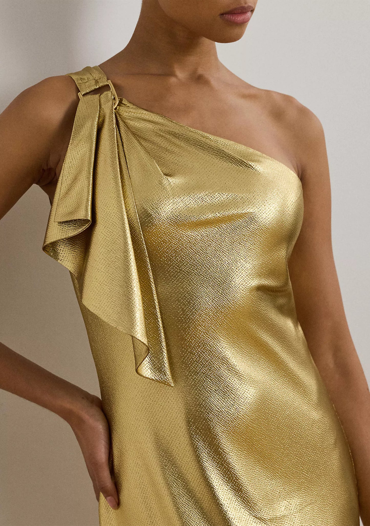 Luxurious one shoulder metallic evening gown with bow detail and floor-length skirt