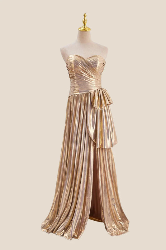 Model wearing a metallic strapless sweetheart A-line prom dress with a dramatic side bow and high front slit.