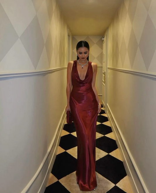 Model wearing a regal satin mermaid prom dress with cowl neck and open back, front view.