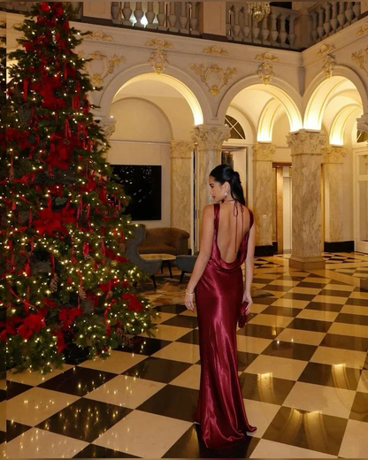 Side profile of a model wearing a floor-length satin mermaid prom dress.