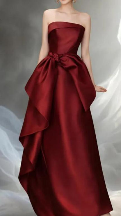 Regal Burgundy Satin Evening Dresses with Strapless Neckline, Floral Bow Detail, Asymmetrical Ruffle Skirt and Floor-Length A-Line Silhouette Formal Gown