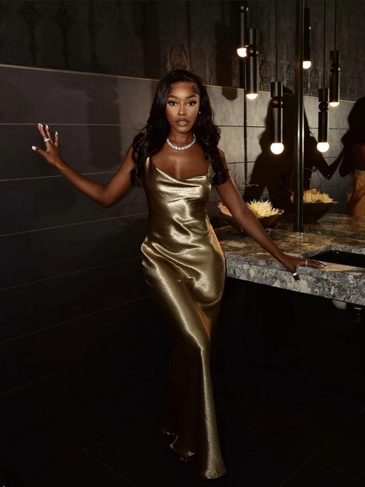 Model wearing a shimmering gold metallic satin mermaid prom dress, front view.
