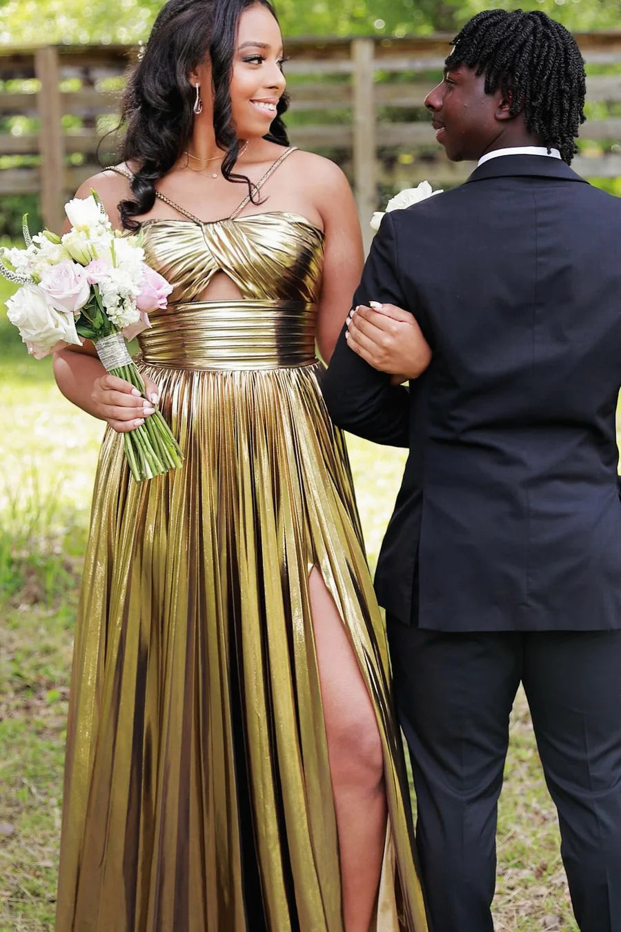 Shimmering metallic dress with pleated waist and flowing skirt.