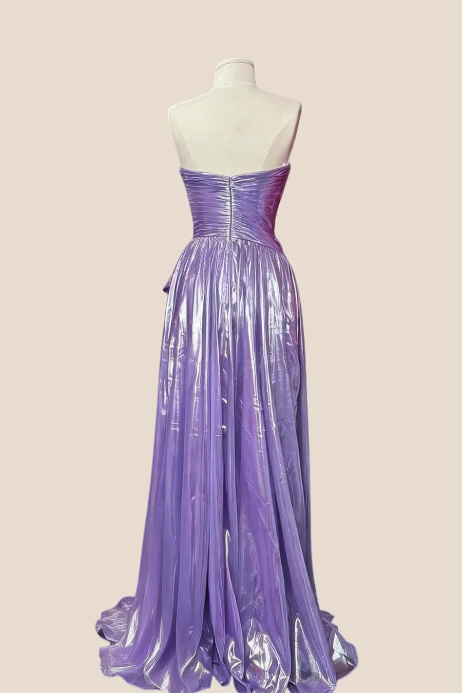 Close-up of the sweetheart neckline, ruched bodice, and bow accent on a metallic dress.