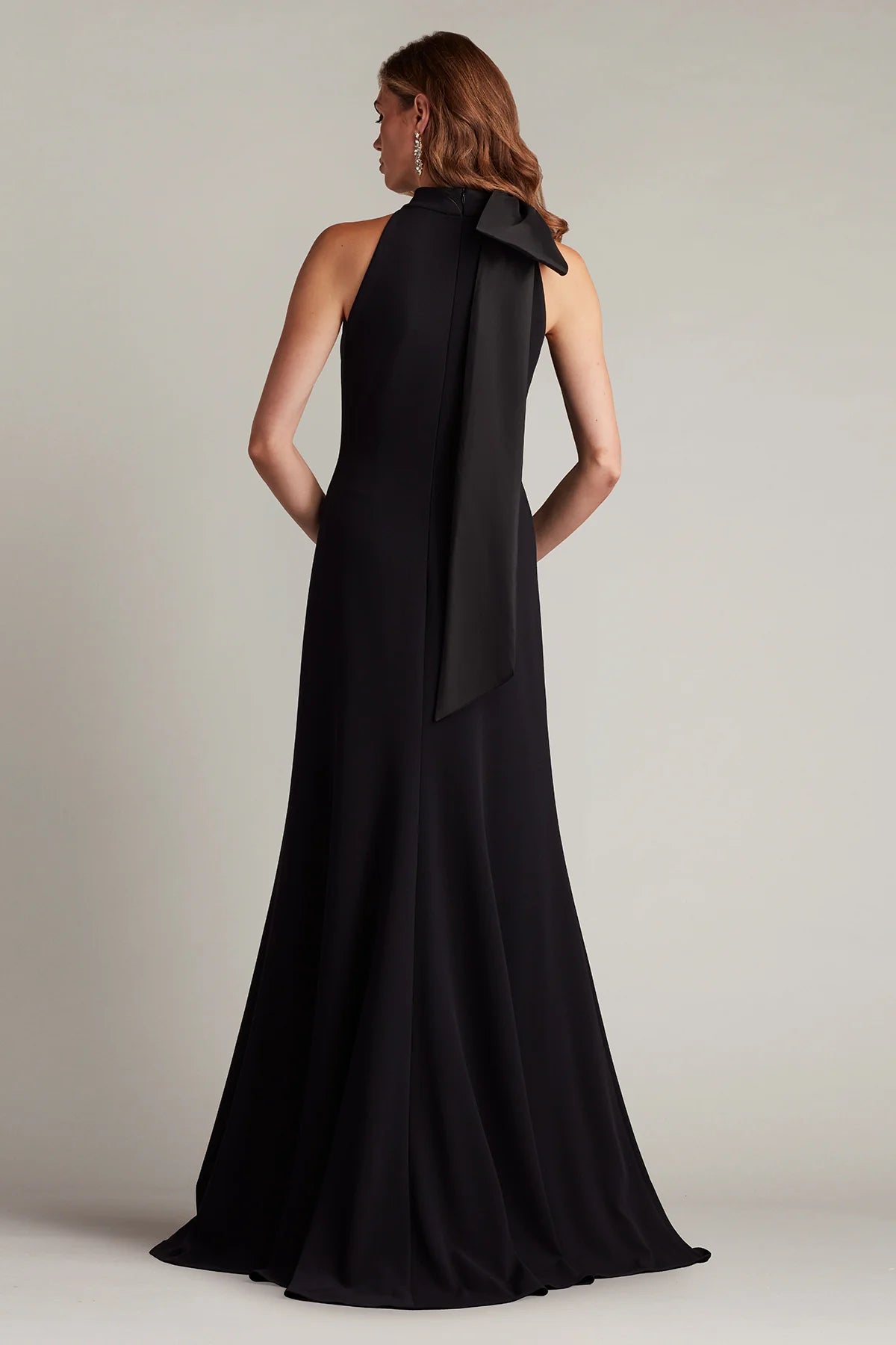 Sleek crepe sheath halter neck sleeveless open back floor length evening dress with oversized satin bow and train