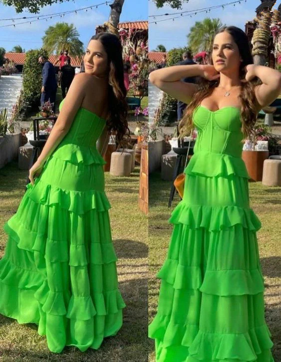 Close-up of the tiered ruffle details and strapless sweetheart neckline on a green prom dress.